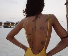 the back of a woman's body with tattoos on it