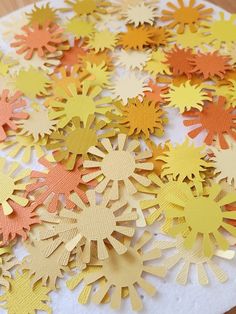 paper cut snowflakes sitting on top of a white plate with orange and yellow strips