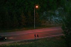 two people walking down the road at night