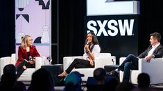 three people sitting on white couches in front of a screen with the sxsw logo