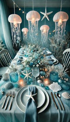 the table is set with plates, silverware and jellyfishs hanging from the ceiling