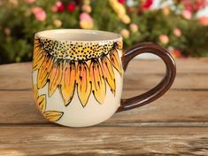 a painted coffee cup sitting on top of a wooden table