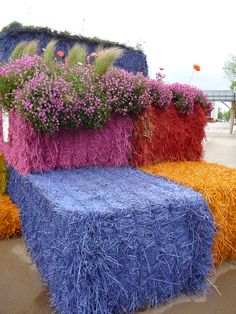 a bench made out of hay and flowers