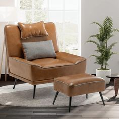 a chair and ottoman in a room with a potted plant on the side table