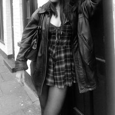 black and white photograph of a woman leaning against a door with her hand on her head