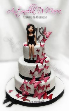 a three tiered cake decorated with butterflies and a woman sitting on top of it