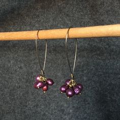 Add a hint of bold color to any outfit with this fun pair of purple clusters.  Bubbly little bunches of dyed freshwater pearls dangle from golden ear wires and glisten with a rich hue.  Lightweight and easy to wear, the ear wires hook into themselves to provide extra security.    Made entirely from reclaimed materials, they are not only good for your wardrobe, but good for the earth as well.   Responsibility sure looks good on you.  Please note: Because many of the beads and components used are Handmade Purple Dangle Pearl Earrings, Purple Dangle Pearl Earrings As Gift, Purple Dangle Pearl Drop Earrings, Purple Pearl Drop Dangle Earrings, Purple Pearl Drop Earrings, Upcycled Earrings, Pearl Cluster Earrings, Grape Soda, Romantic Earrings