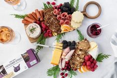 two platters filled with meats, cheese and fruit on top of a table