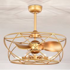 a gold ceiling fan with three blades on it's head and two lights in the middle