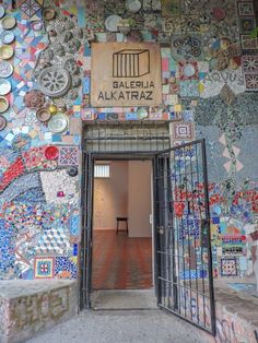 the entrance to an art gallery with colorful tiles on the walls and doors, which are decorated in different colors