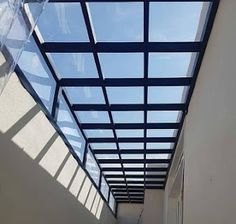 an empty hallway with glass roof and skylights on the ceiling is seen in this image