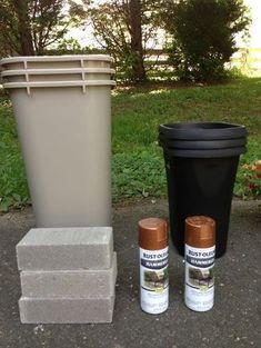 two cans, one black and one brown next to a trash can