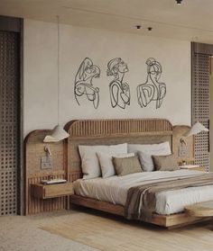 a large bed sitting in a bedroom next to a wall with two drawings on it