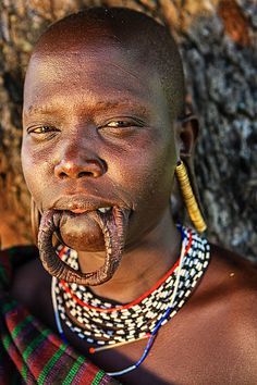 an african woman with her mouth open and tongue hanging out to the side, standing in front of a rock wall