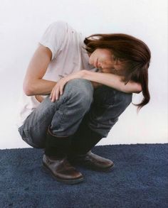 a woman sitting on the floor with her head down