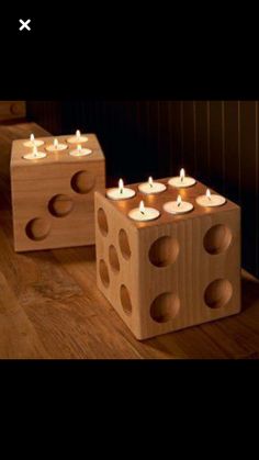 two wooden blocks with candles in them sitting on the floor next to eachother