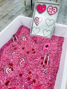 a pink box with hearts and scissors in it