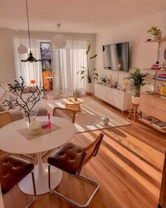 a living room filled with furniture and a flat screen tv on top of a wooden floor