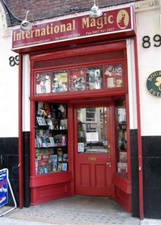 the entrance to an international magic store with its red door and sign on the side