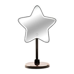 a star shaped mirror on a stand with a black base and white back dropper