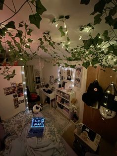 a laptop computer sitting on top of a bed in a room filled with plants and lights