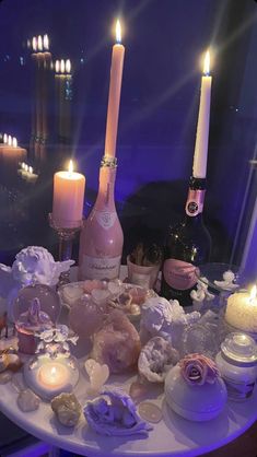 a table topped with candles and bottles filled with different types of confection items