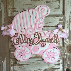 a pink and white baby carriage door hanger