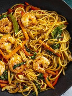 a pan filled with pasta and shrimp on top of a table