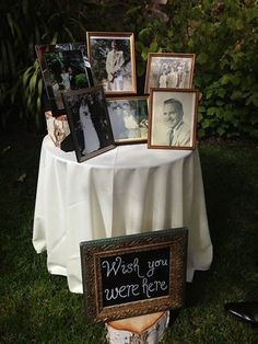 a table topped with pictures and framed photos next to a sign that says wish you were here