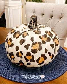 a painted pumpkin sitting on top of a blue mat