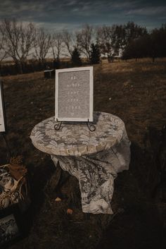 a table with a sign on it sitting in the middle of a field