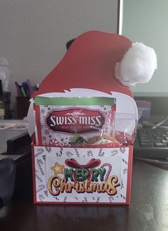 a christmas card box with a santa's hat on top and candy in the bottom