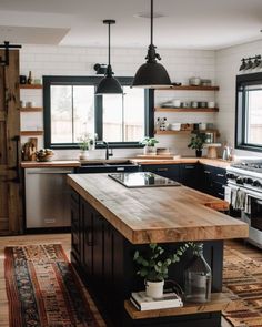 a kitchen with black cabinets and an island in front of a stove top oven next to a sink