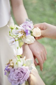 two bridesmaids holding bouquets of flowers in their hands, one is white and the other is purple