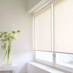 a vase filled with flowers sitting on top of a white shelf next to a window