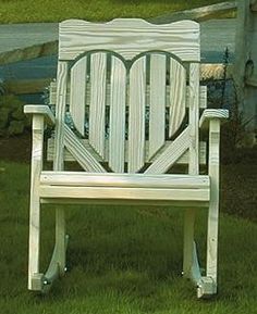 a white wooden chair sitting in the grass