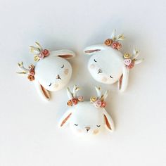 three ceramic rabbits with flowers on their ears