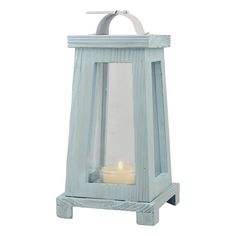 a small blue lantern with a lit candle in the middle and a white handle on top