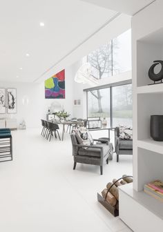 a living room filled with furniture next to a window covered in lots of white walls