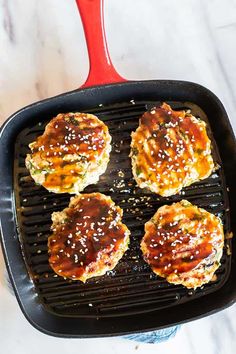 four hamburger patties cooking on a grill