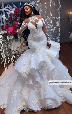 a woman in a wedding dress standing next to flowers