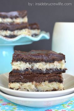 two pieces of cake sitting on top of a white plate next to a blue bowl