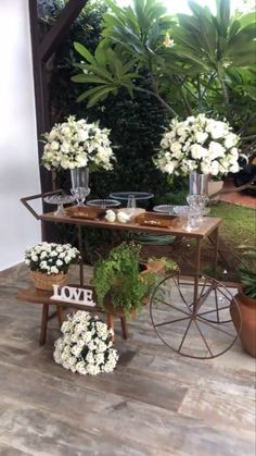 the table is set up with vases and flowers