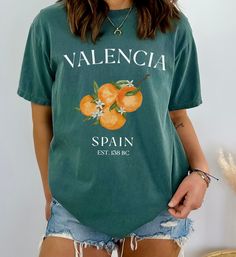 Valencia Spain Oranges Tee Shirt, Cute Unisex Espana Tshirt The Comfort Colors C1717 100% Ring Spun Cotton T-Shirt is very appropriately-named. All colors are inspired by nature and have a perfect lived-in, weathered look. Shirts are sent through a unique dyeing process that makes them incredibly soft and long-lasting. Each piece is soft-washed 50 times before making its way to you! Stitched at the collar, armhole, sleeves and bottom hem for ultimate durability, you will notice the density and q Casual Branded Summer T-shirt, Casual Branded T-shirt For Summer, Casual Summer T-shirt With Branding, Green Logo Print T-shirt For Spring, Green Summer T-shirt With Slogan, Green Basic Shirt With Letter Print, Basic Green Shirt With Letter Print, Green Logo Print Shirt For Summer, Green Logo Print Summer Shirt