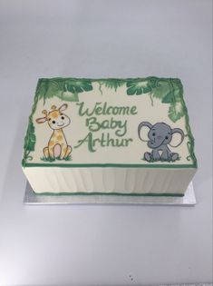 a baby shower cake with an elephant and giraffe on it