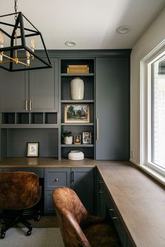 a home office with built in bookcases and leather chairs next to the desk