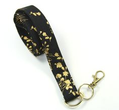 This cute lanyard has gold flowers on black. It is perfect for any occasion. You can leave me a convoy if you need a different size. You can have a wardrobe of lanyard to match your outfit. This lanyard is made of soft 100% cotton fabric to give a comfortable feel around your neck. This lanyard is easy to take care. You can spot clean and throw in a washer and hang dry. If you want you can iron and it is ready to use. These lanyards are perfect if you have metal allergy. Each of these lanyards w Adjustable Black Lanyards For Personal Use, Black Lanyard With Key Leash For Personal Use, Black Lanyard With Key Leash As Gift, Cute Lanyard, Cute Lanyards, Black Lanyard, Fabric Lanyard, Golden Flower, Have Metal