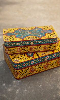 two yellow and blue boxes sitting on top of a cement floor next to each other