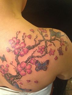 a woman's back with pink flowers and butterflies on it