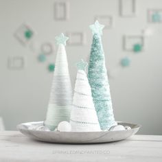 three small christmas trees sitting on top of a table next to each other in a bowl